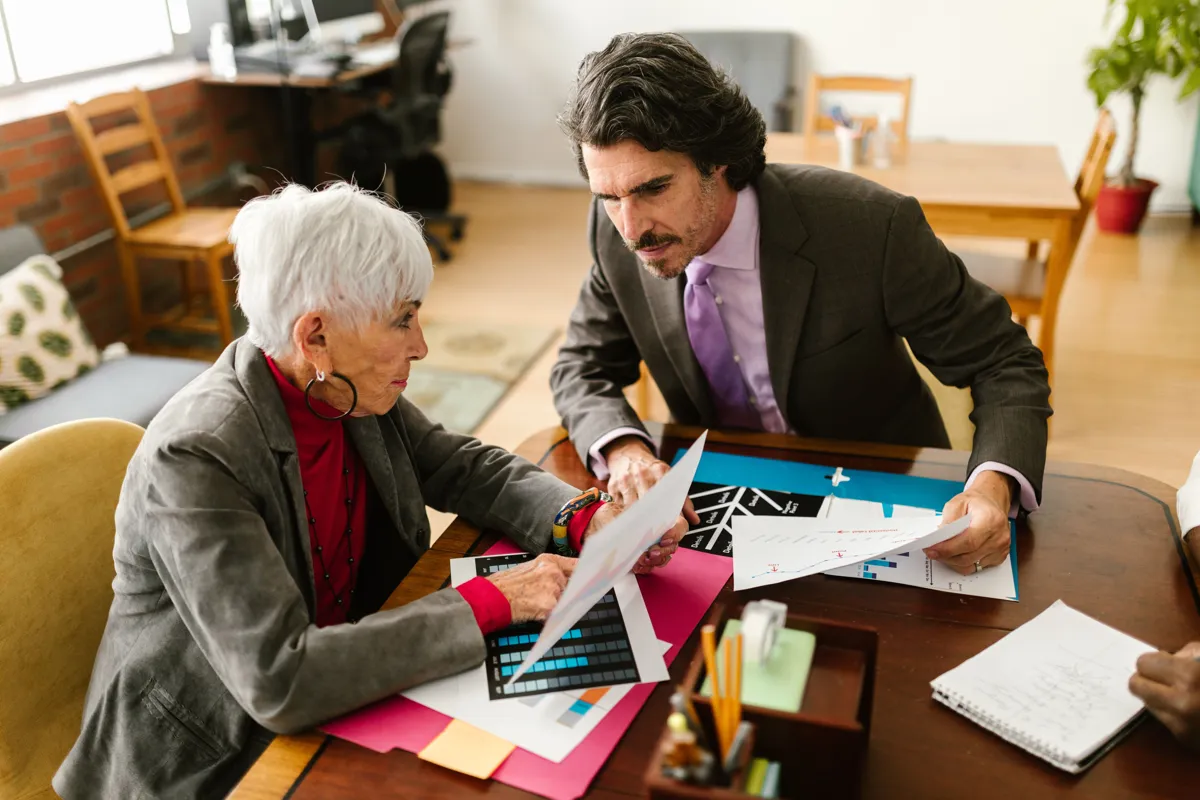 An advocate going through documents at a table with an older woman